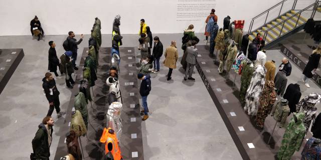 Visitors studying four of the 12 thematic sections (camouflage, flight jackets, armour, and the proletariat) within the exhibition